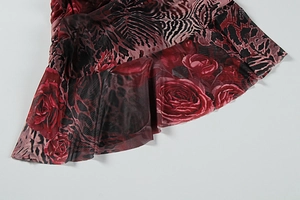 Détail du tissu en maille avec imprimé fleuri rose rouge, léopard et bords à volants