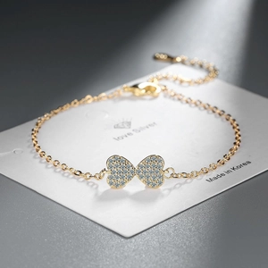 Elegant gold bow-shaped bracelet with pavé white zircons and sparkling heart details