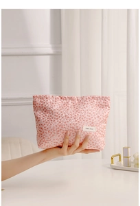 Close-up of pink floral texture makeup bag with drawstring closure and brand label