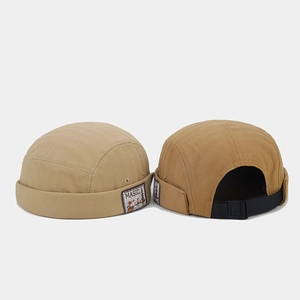 Detail of vintage patches and adjustable nylon straps on khaki and yellow miki hats
