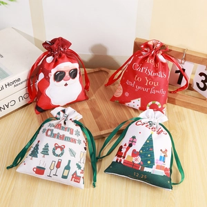 Set of 4 Christmas drawstring gift bags with Santa patterns on light wooden background