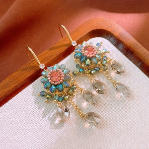 Detail of flower earrings with blue and pink crystals and transparent water drop pendants