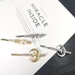Detailed view of four star and moon hairpins in gold and silver with rhinestones
