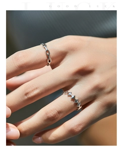 Detailed macro view of S925 silver chain link and star pattern rings on a hand