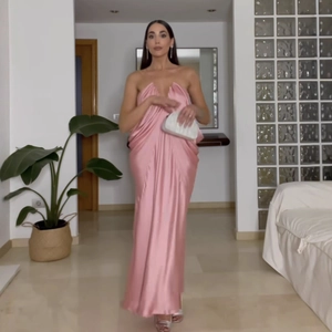 Detail of pink satin floor-length tube dress showing smooth fabric and slim fit design