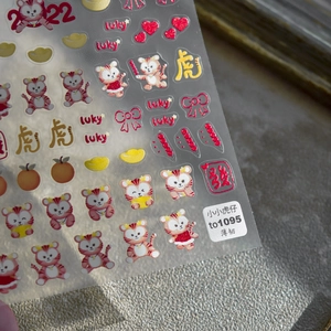 Detail of 5D embossed nail stickers featuring cute cartoon tigers and festive patterns