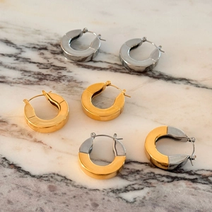 Detailed view of polished C-shaped hoop earrings in gold, silver, and two-tone finishes