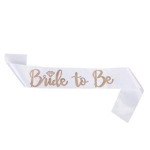 Close-up of white satin sash with rose gold Bride to Be text and diamond icon