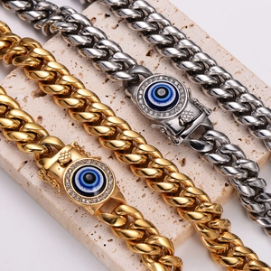 Dettaglio di un bracciale a catena cubana in acciaio con charm occhio blu