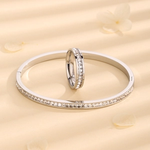 Silver stainless steel jewelry set with square zircon ring and bracelet on petal background