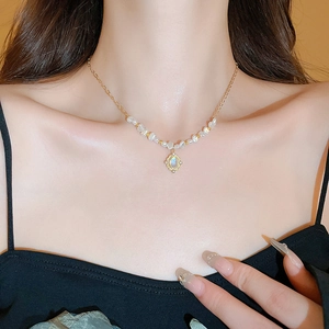 Détail du collier doré de style français avec perles baroques et pendentif gemme
