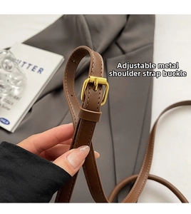 Detail of adjustable leather strap with polished gold metal buckle and precision stitching