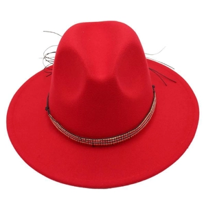 Vue de dessus d'un chapeau fedora rouge en laine avec ruban perlé noir et plume décorative