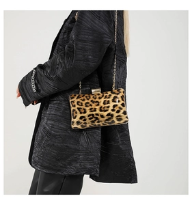 Detail showing high-quality leopard print texture and golden chain on a evening bag