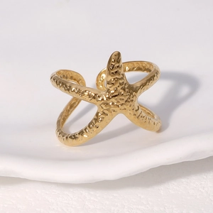 Verstellbarer goldener Seesternring mit Hammerschlag-Optik auf weißem Grund