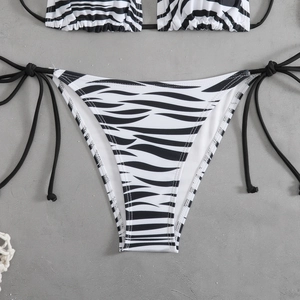 Detail view of zebra print bikini bottoms with adjustable side ties on grey background