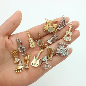 Variety of gold and silver musical instrument charms including piano and violin with rhinestones