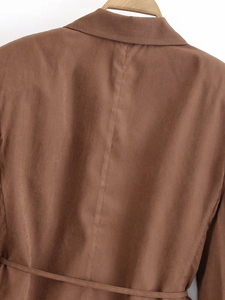 Back view detail of brown blazer jacket showing waist belt and shoulder seam stitching