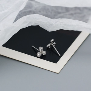 Macro detail of 925 sterling silver clover stud earrings with sparkling cubic zirconia