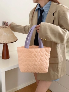 Quilted heart peach tote bag with purple handles shown in a lifestyle setting