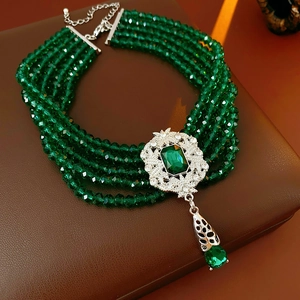Macro detail of luxury vintage emerald green beaded necklace with filigree metal work