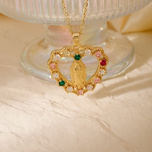 Golden heart pendant with Virgin Mary engraving and colorful zircons on a glass base