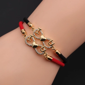 Detail of red and black woven couple bracelets with gold I, U and heart charms