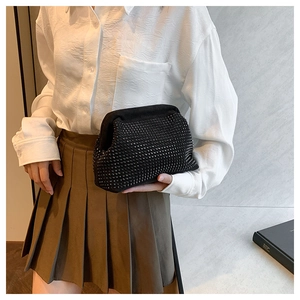 Detailed view of luxury black clutch bag with shimmering rhinestones and metal frame