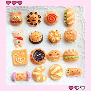 Assorted resin miniature food charms including donuts and croissants on a white plate
