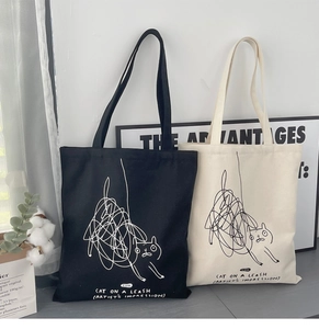 Detail of artistic cat graffiti pattern on minimalist black and beige canvas tote bags