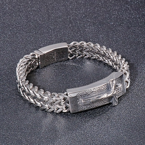 Macro shot of silver men's titanium steel bracelet with cross feather details
