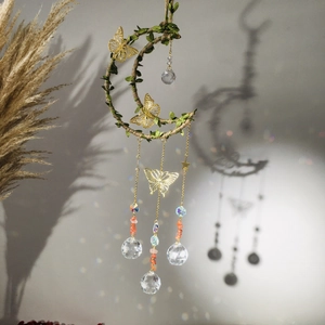 Handmade moon wind chime with crystals, leaves and golden butterflies hanging on wall