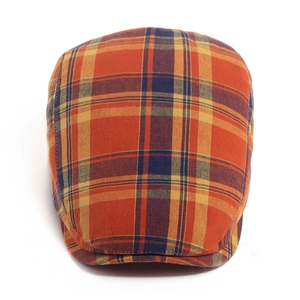Classic plaid flat cap in orange, yellow and navy blue Scottish tartan with cotton texture
