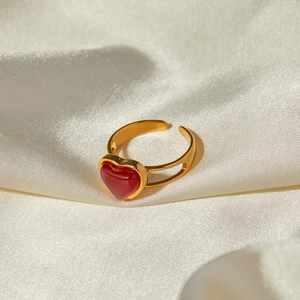 Close-up of 18k gold heart-shaped red agate ring on white silk background