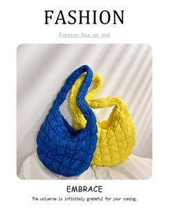 Detail showing blue and yellow quilted puffer bag texture with wave padding design