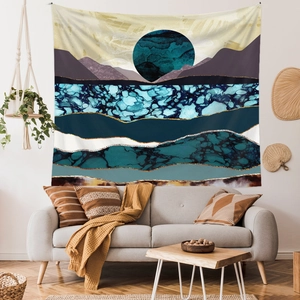 Detail of mountain tapestry with golden lines hung above a sofa in a modern living room
