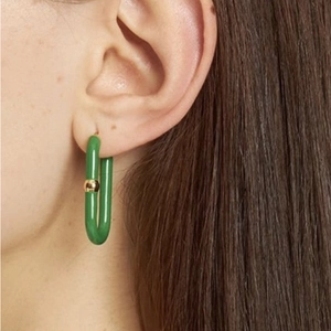 Close-up of a model wearing a green U-shaped drop earring with 18K gold metal link