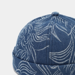 Macro shot of dark blue denim miki hat fabric with white leaf pattern embroidery