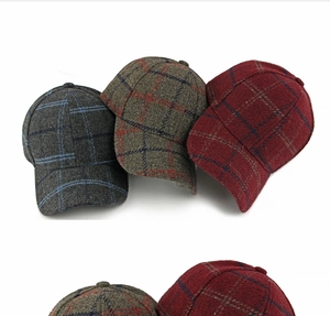 Detail of wool plaid baseball caps in three colors showing textured tweed fabric