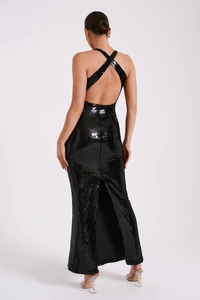Detail of the backless cross-strap design on a black sequin evening gown dress