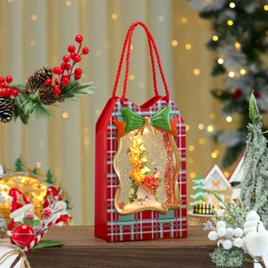 Close-up of lighted Christmas gift box music box with swirling snow and festive decor