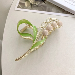 Detailansicht der Maiglöckchen Haarklammer mit grünen Blättern und rosa Perlen