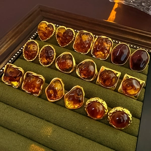 Macro view of assorted amber resin stud earrings with gold geometric metal settings