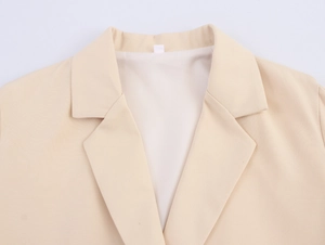 Close-up of beige blazer notch lapel and smooth inner lining fabric texture