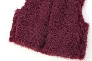 Detailed view of the deep burgundy faux fur vest hem showing texture and soft plush fibers