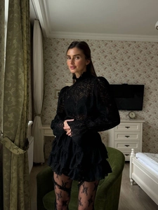 Detail of black lace set featuring high neck top and layered ruffle cake skirt texture