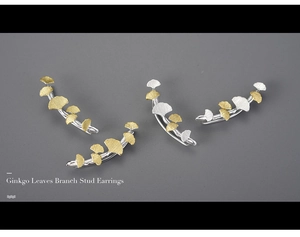 Detail of ginkgo leaf branch stud earrings in gold and silver with frosted texture