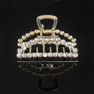 Macro detail of 7.7cm gold hair claw clip with multi-row rhinestone and mirror reflection