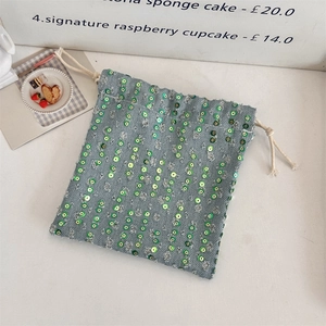 Close-up of denim drawstring bag with green sequins and sturdy cotton rope detail