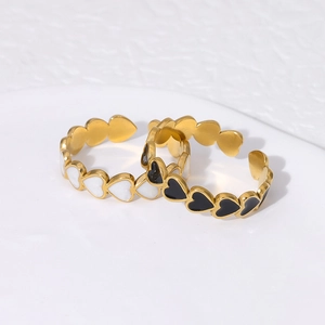 Detail of gold-plated heart rings with black and white enamel in adjustable open design